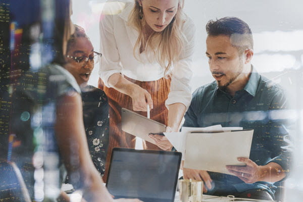 People looking a papers and a tablet