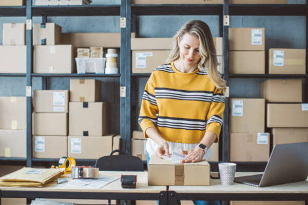 Woman Packing a box with shipping tape