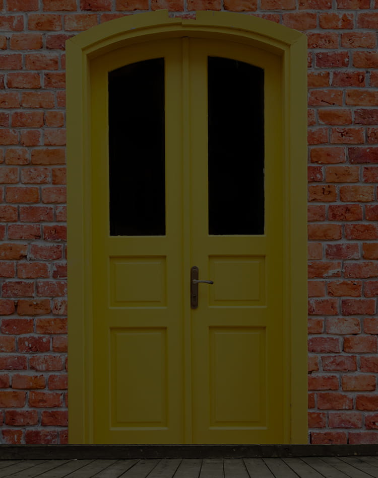 Yellow door on a brick wall