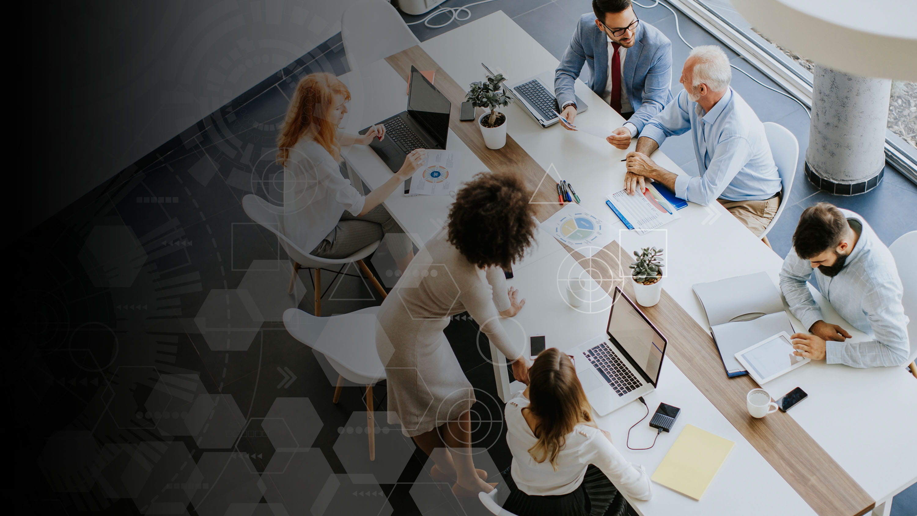 People all working around a table with laptops and papers