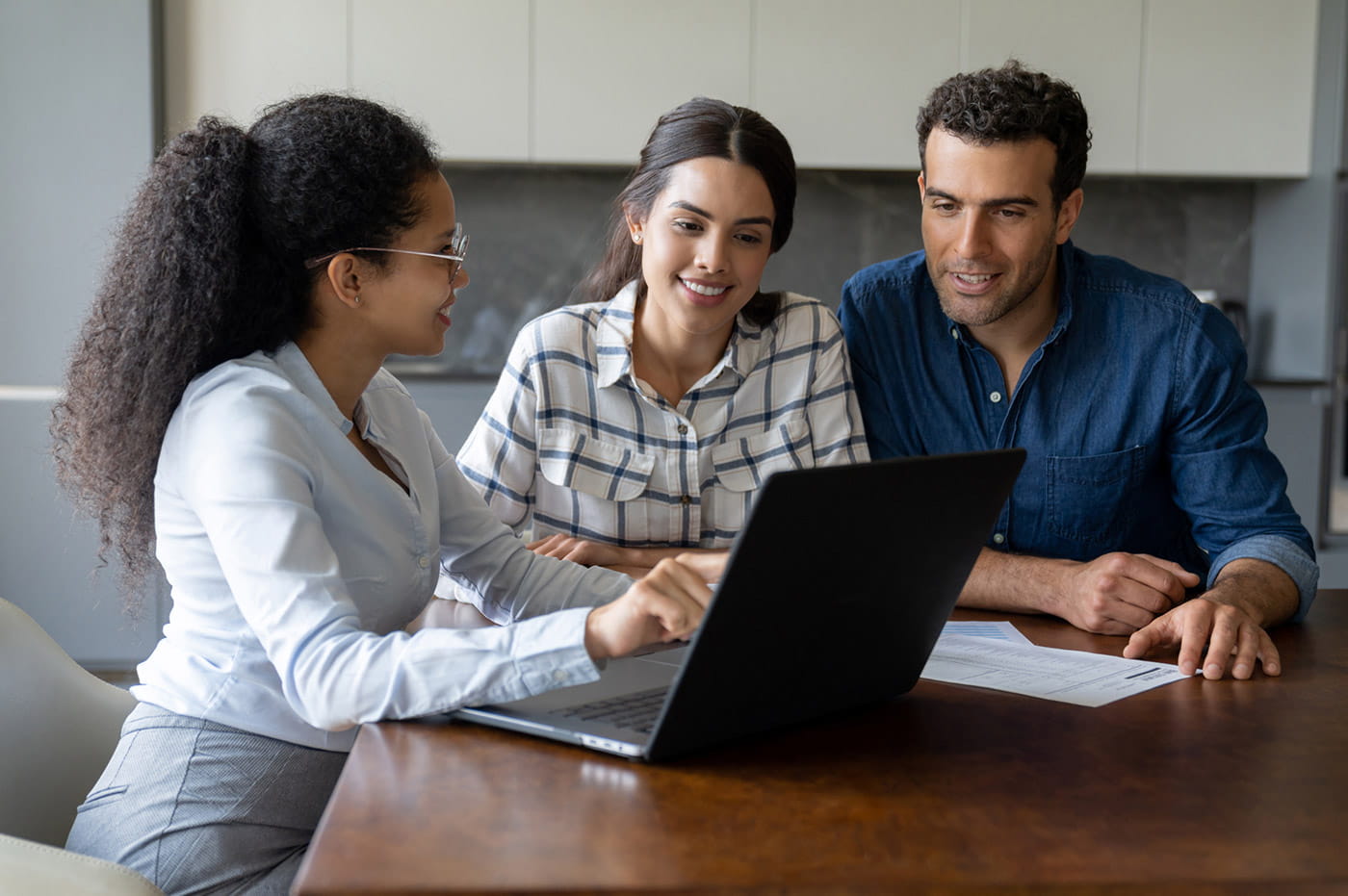 A couple looking at a computer screen with an employer in an office space. 
