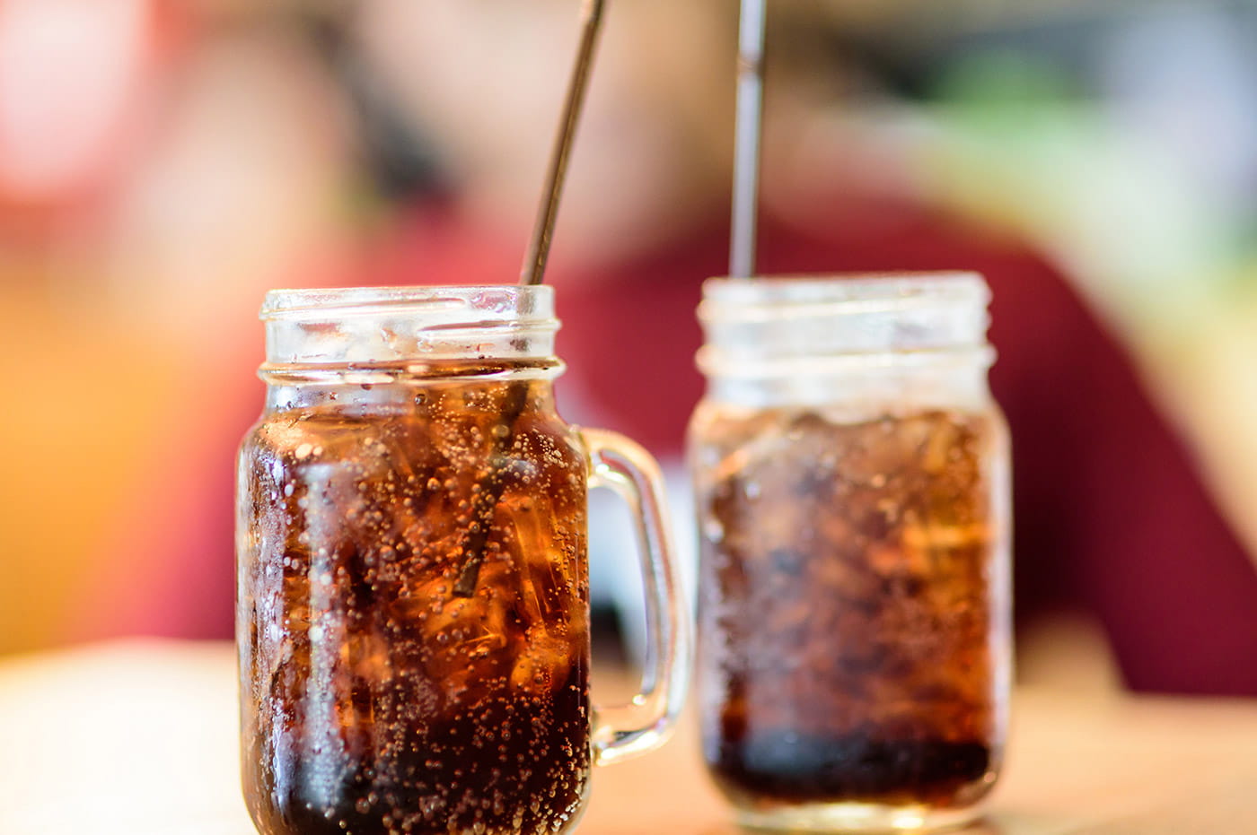 Two mason jars with a brown soda.
