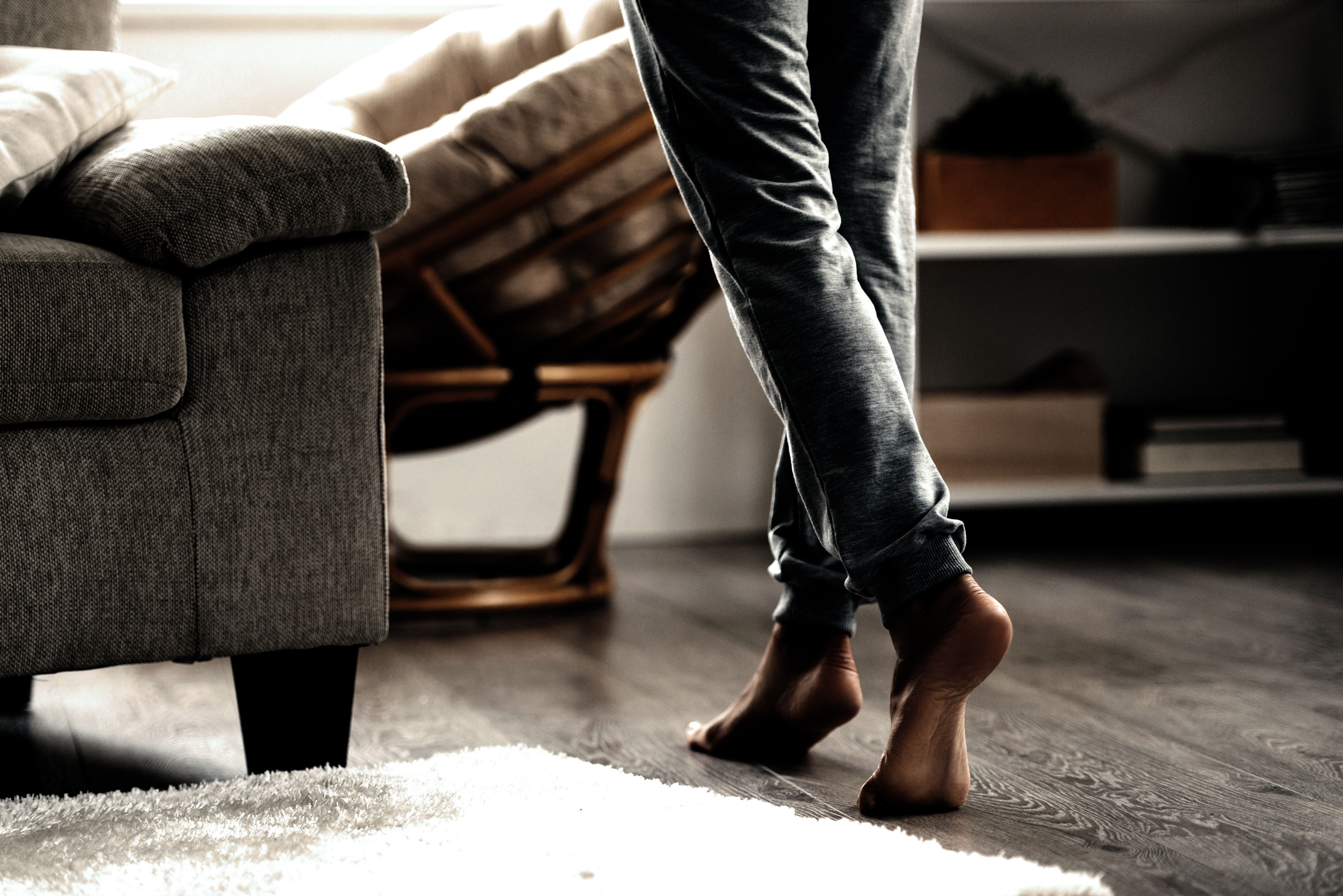 Someone dancing in a room with a white area carpet.