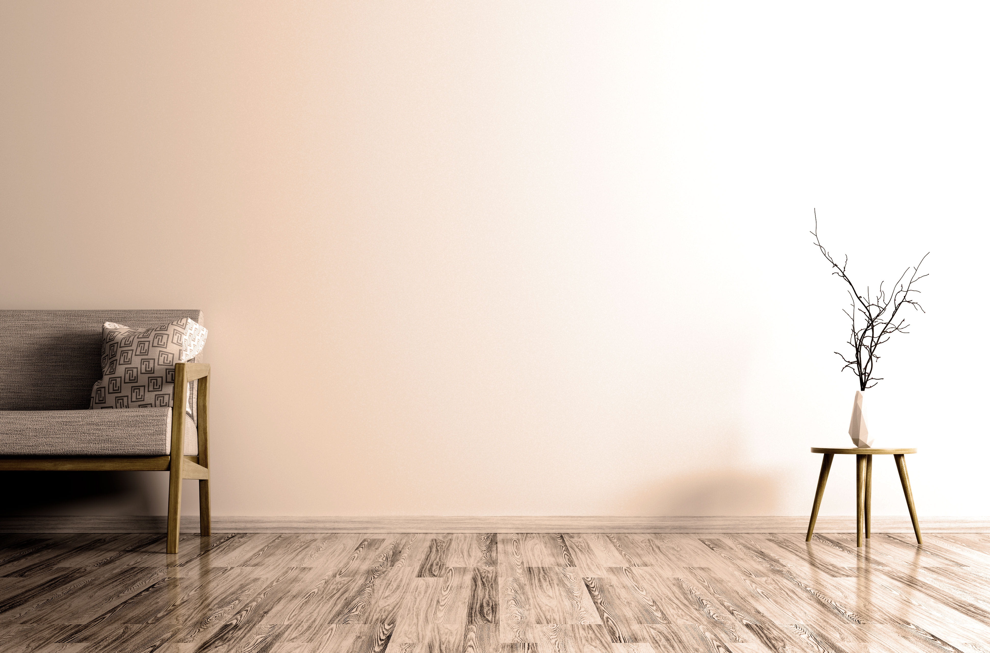 A couch and vase full of branches positioned against a wall.