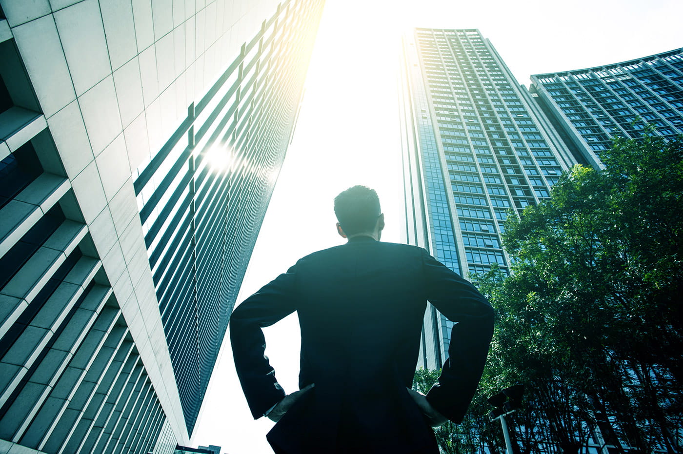 A man looking up at a skyscape with high-rises.