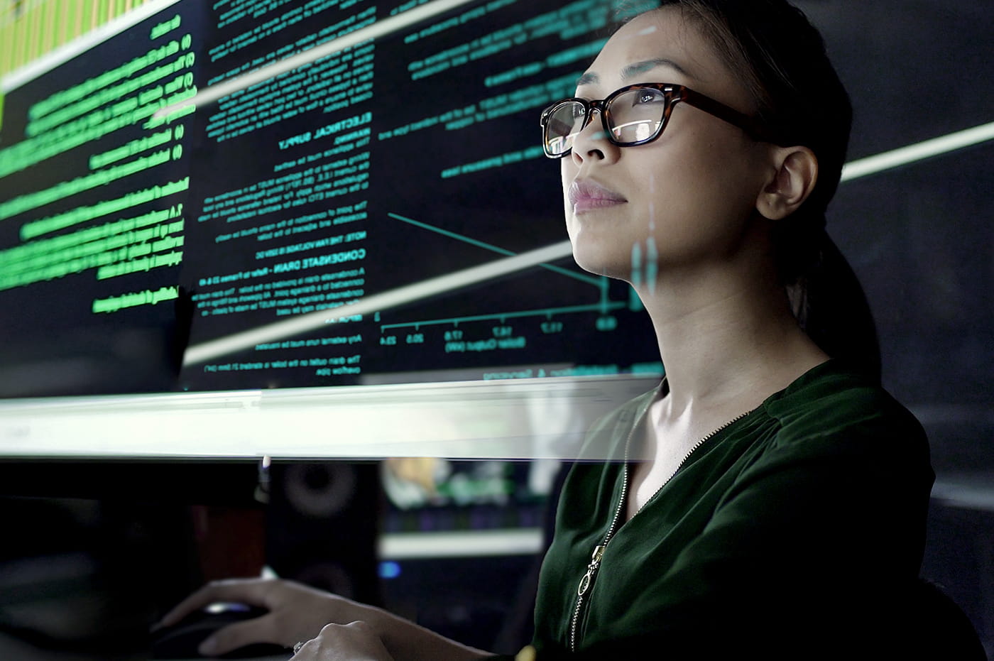 A woman wearing glasses looking at data.