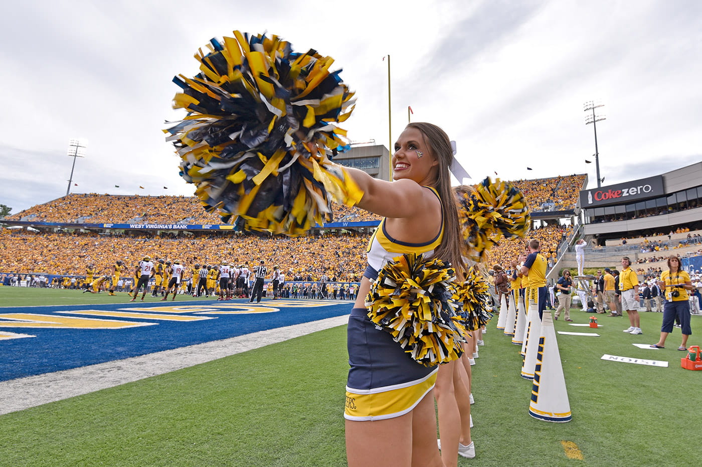 A college cheerleader on a football field.