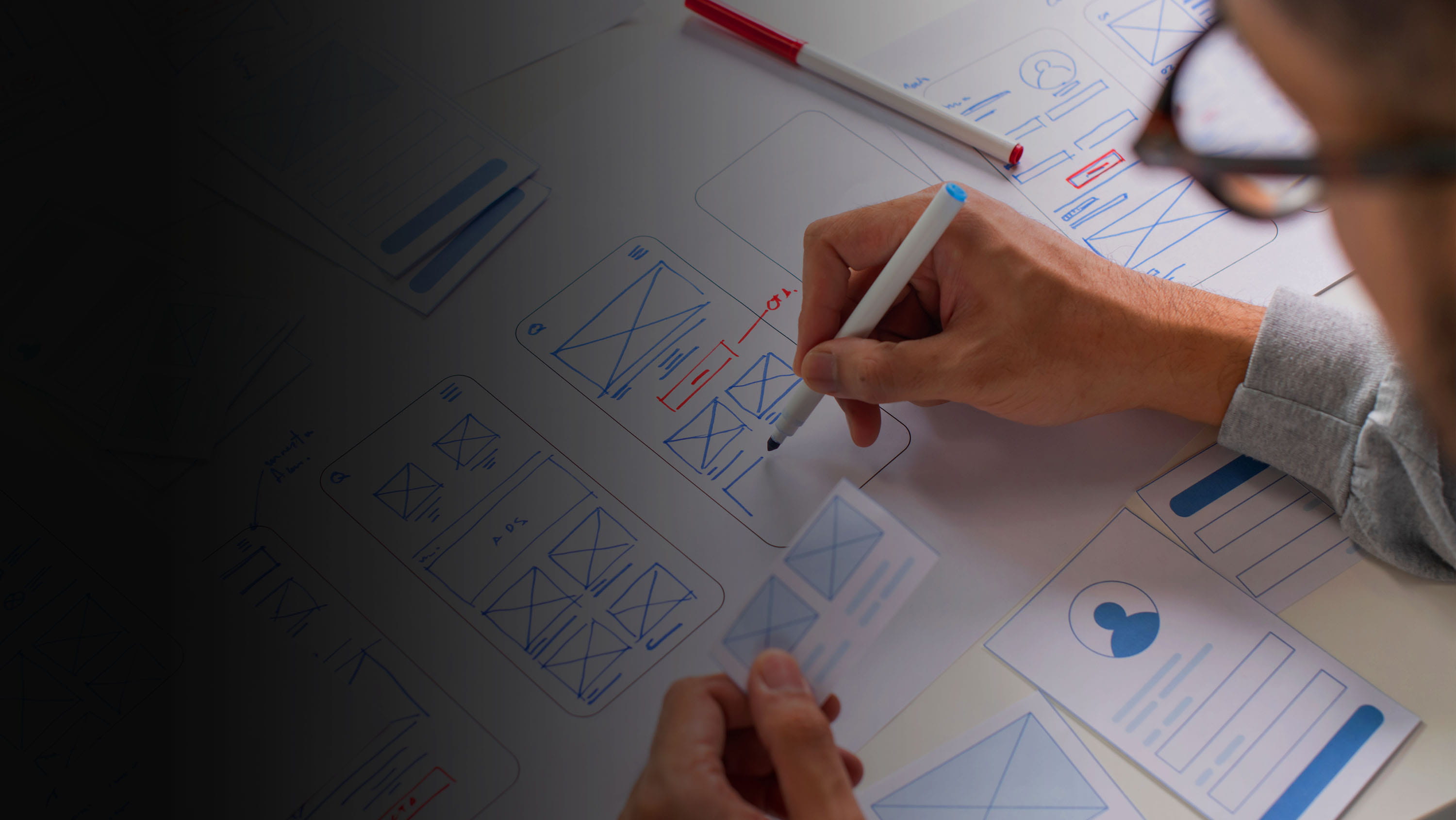 Person writing on pieces of paper with charts