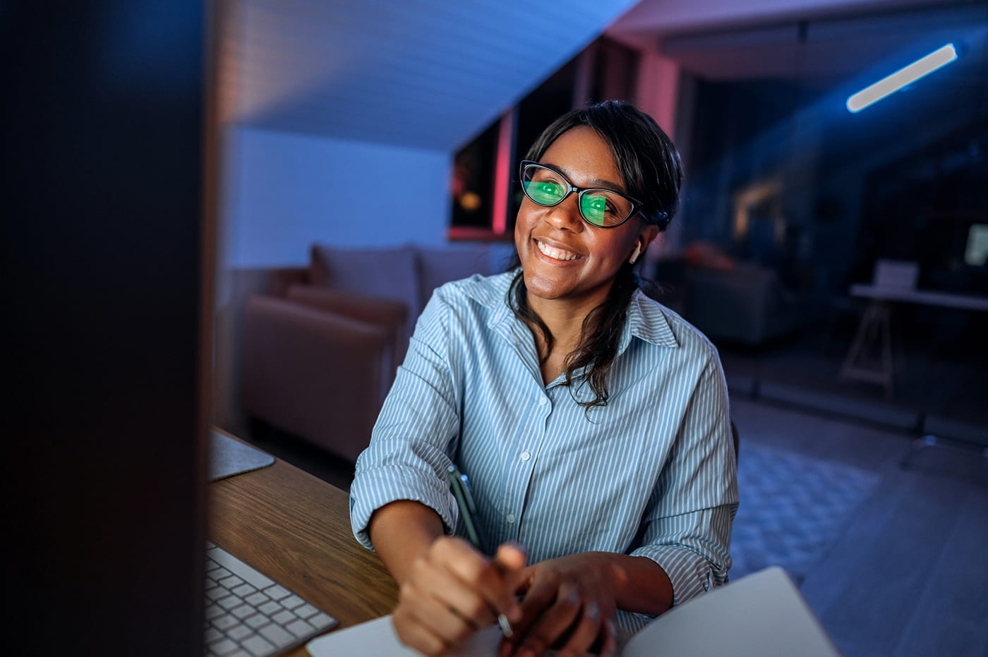Woman smiling looking at a computer screen. 