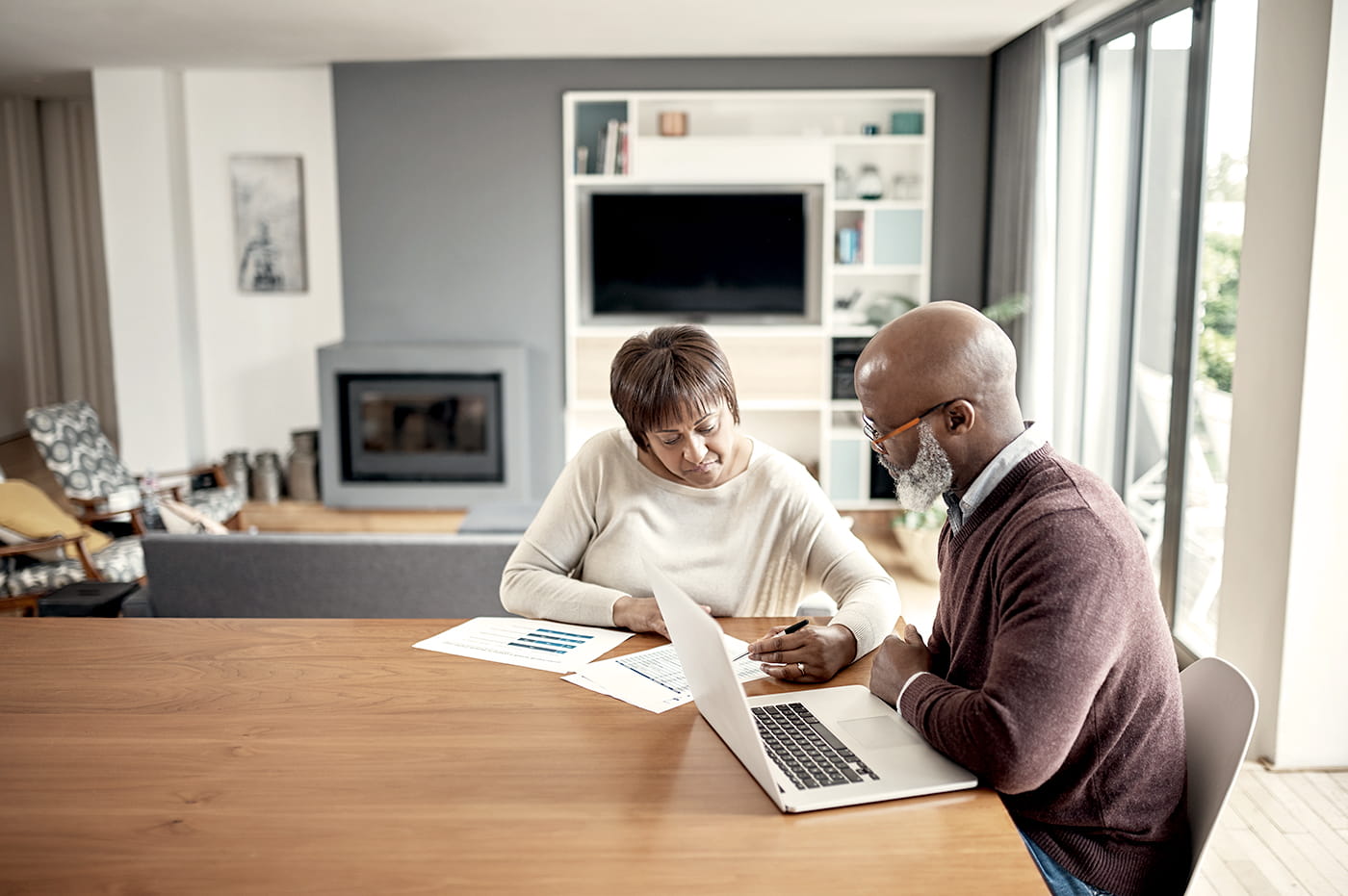 man and woman looking at healthcare data on laptop at home